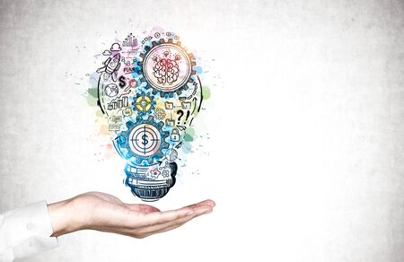 Hand of businessman in white shirt showing colorful business idea sketch drawn on concrete wall. Concept of planning and brainstorming. Mock upの写真素材