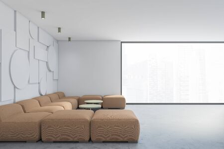 Side view of stylish spacious living room with white geometric pattern walls, concrete floor, big beige sofa and two green coffee tables. Panoramic window with blurry cityscape. 3d renderingの写真素材
