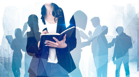 Unrecognizable young businesswoman writing in notebook in blurry abstract city with double exposure of her teammates. Concept of leadership and management. Toned imageの写真素材