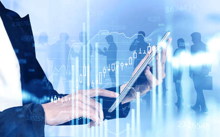 Unrecognizable businesswoman using tablet over blurry blue background with double exposure of her...