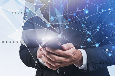 Hands of businessman using smartphone over blurry blue background with double exposure of immersive network interface. Concept of technology and communication. Toned imageの写真素材