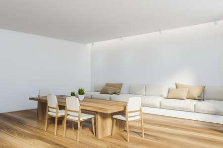Corner of modern dining room with white walls, wooden floor, long table with white chairs and long...