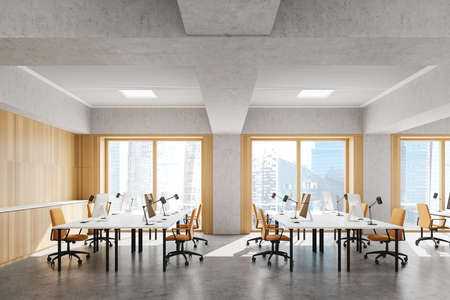Side view of loft open space office with wooden and concrete walls, concrete floor, rows of computer...