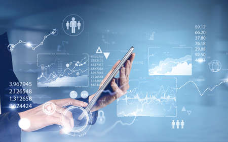 Hands of unrecognizable businesswoman using tablet in blurry office with double exposure of HUD...