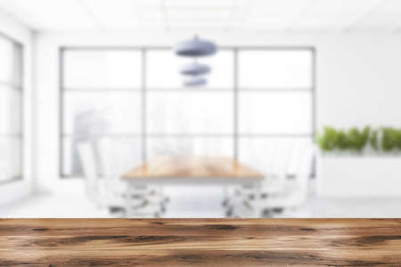 Wooden table for your product in blurry meeting room with white walls, concrete floor, conference...