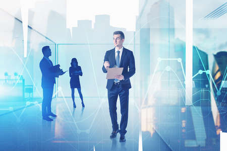 Businessman with clipboard and his colleagues working together in blurry office with double exposure of cityscape and financial charts. Toned imageの写真素材