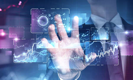 Hand of businessman using immersive infographic interface in blurry office. Concept of hi tech....