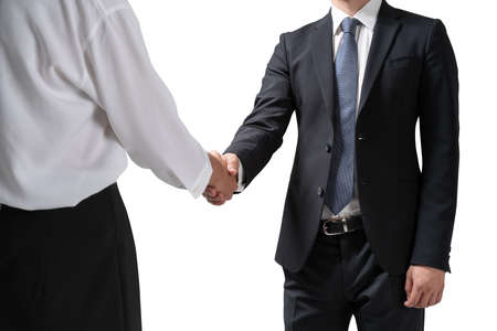 Isolated portrait of two unrecognizable young businessmen shaking hands. Concept of partnership