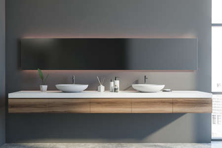 Interior of modern bathroom with gray walls, concrete floor, double sink and long mirror. 3d...