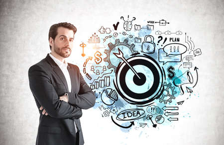 Portrait of confident bearded businessman standing near concrete wall with business goal sketch...