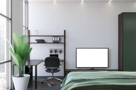 Modern TV with mock up screen standing in bedroom with white walls, concrete floor and home office...