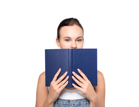 Isolated portrait of young businesswoman standing with book over white background. Concept of...