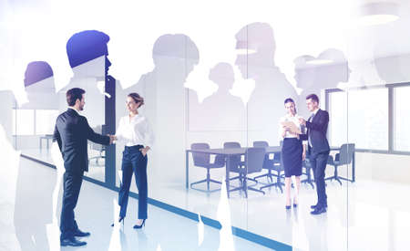 Business people shaking hands in meeting room with double exposure of their business team. Toned imageの写真素材