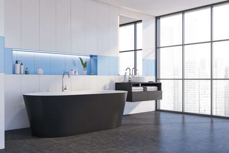 Corner of minimalistic bathroom with white and blue walls, concrete floor, comfortable bathtub and...