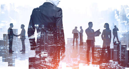 Silhouettes of successful business people working together in blurry city. Concept of teamwork. Toned imageの写真素材