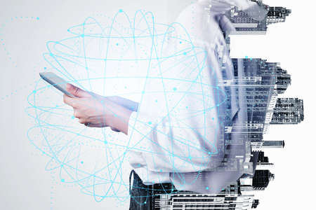 Close up of young businesswoman using tablet in blurry city. Concept of technology and...