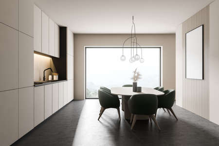 Side view of panoramic kitchen with white walls, concrete floor, white cupboards and dining table...
