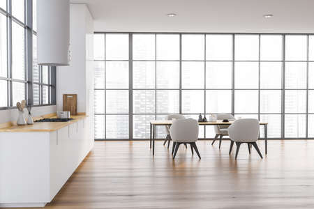Interior of stylish panoramic kitchen with white walls, wooden floor, white cupboards and dining table. 3d renderingの写真素材