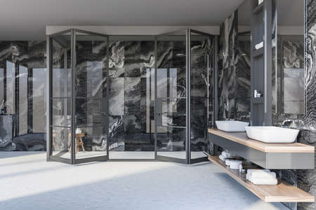 Interior of luxury bathroom with black marble walls, concrete floor, double sink with two mirrors...