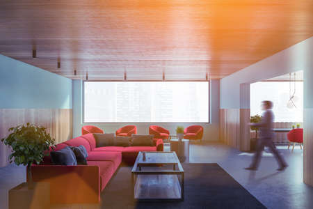 Blurry young man walking in modern dining room with blue and wooden walls, concrete floor and dining...
