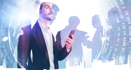 Side view of young businessman with smartphone standing in blurry city with double exposure of his...