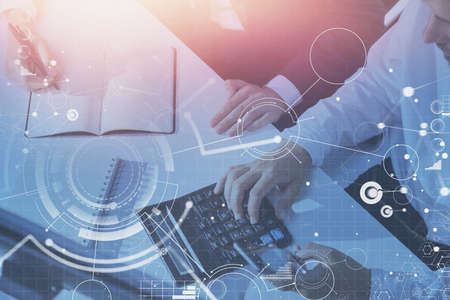 Top view of businessman and businesswoman working together in office with double exposure of network...