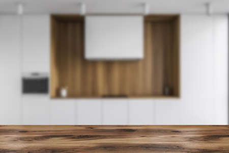 Wooden table for your product in blurry stylish kitchen with white and wooden walls, wooden floor and dark wooden cupboards. 3d renderingの写真素材