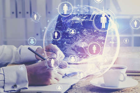 Hands of businessman using laptop in blurry office with double exposure of HR interface and planet...