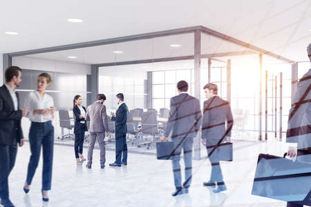 Portrait of business people working together in blurry office. Concept of teamwork. Toned image double exposure of skyscraperの写真素材