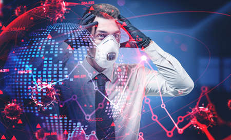Portrait of panicking businessman in mask standing in blurry office with double exposure of covid 19 coronavirus, planet hologram and graphs. Toned imageの写真素材