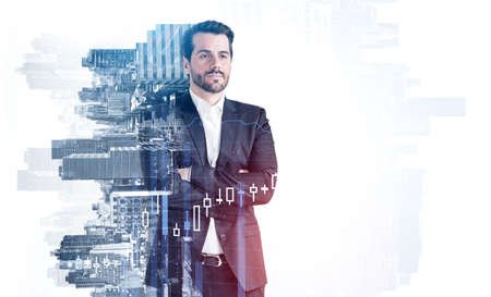 Portrait of confident young European businessman standing with crossed arms in blurry city. Concept...