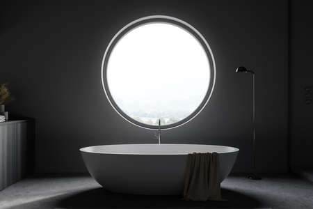 Interior of stylish bathroom with gray walls, concrete floor, comfortable bathtub and round window. 3d renderingの写真素材