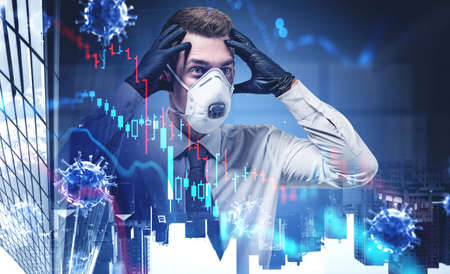 Portrait of panicking businessman in mask standing in blurry city with double exposure of covid 19 coronavirus and falling graphs. Toned imageの写真素材