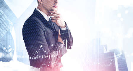 Portrait of unrecognizable thoughtful businessman standing in blurry city with double exposure of...