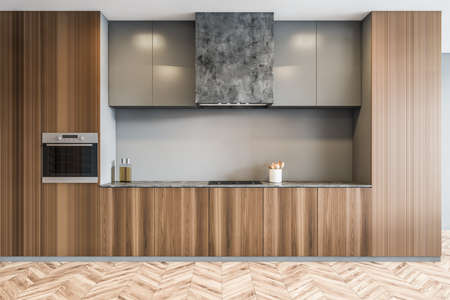 Minimalist wooden kitchen set front view in new modern apartment, open space kitchen on parquet...