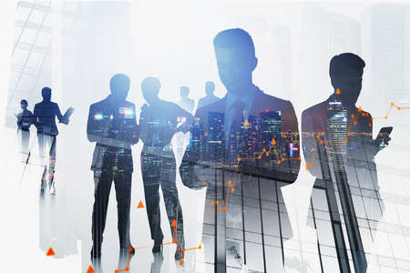 Silhouettes of business people in blurry city with double exposure of graphs. Concept of teamwork....