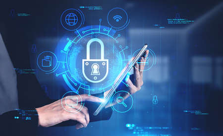 Young businesswoman hand using tablet in blurry office with double exposure of cyber security...