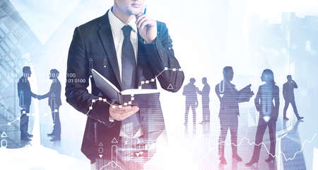 Unrecognizable thoughtful businessman with book standing in blurry city with his team. Double exposure of graphs. Toned imageの写真素材