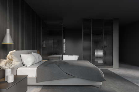 Interior of stylish master bedroom with gray and wooden walls, concrete floor and comfortable king size bed. Bathroom next to it. 3d renderingの写真素材