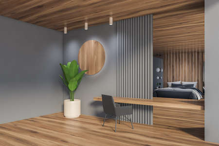 Corner of minimalistic home office with gray walls, wooden floor and table with gray armchair. 3d...