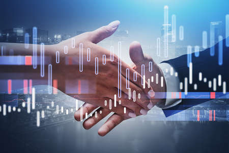 Close up of businessman and businesswoman shaking hands with double exposure of graphs. Toned image