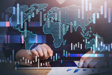 Unrecognizable businessman using tablet in blurry office with double exposure of world map and...