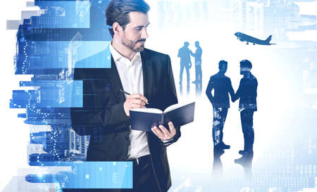 Confident young businessman standing with his team in blurry city with double exposure of charts. Toned imageの写真素材