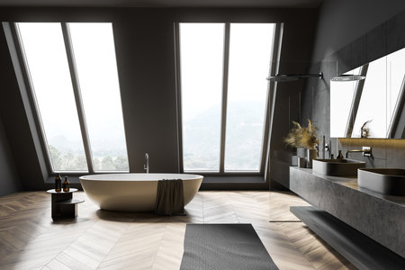 Side view of attic bathroom with gray walls, wooden floor, comfortable bathtub, double sink and shower stall. 3d renderingの写真素材