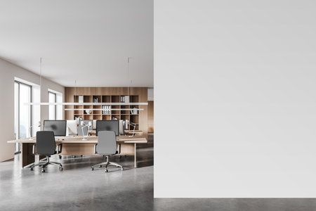 Interior of modern open space office with white and wooden walls, concrete floor and rows of computer tables. Mock up wall to the right. 3d renderingの写真素材
