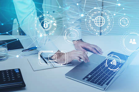 Double exposure of businessman hand working with business documents at office workspace with laptop...