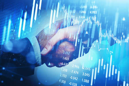 Double exposure of businessman handshake on stock market graph background. Concept financial...