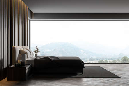 Master bedroom with gray wooden walls, panoramic window with countryside view, comfortable king size bed standing on gray carpet and wooden parquet floor. 3d renderingの写真素材