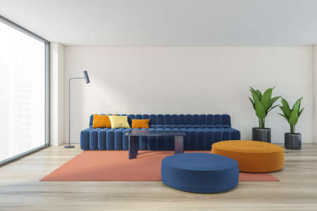 Beige light living room with large blue sofa with pillows, plants and cushions on the wooden parquet...
