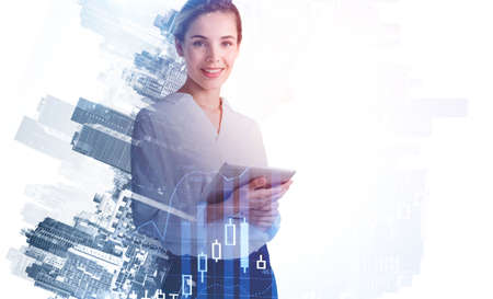 Attractive smiling business woman researching the analytics to predict stock market behavior. Forex chart and New York on background. Double exposureの写真素材